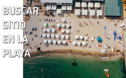 Una playa con sombrillas y mucha gente