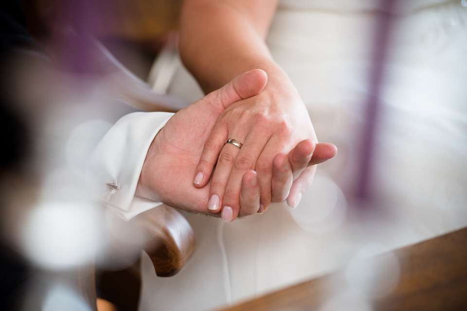 Sacerdote toma la mano de la novia