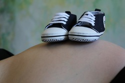 Barriga de una mujer embarazada con zapatitos