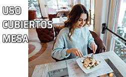 Una mujer utiliza los cubiertos para tomar los alimentos