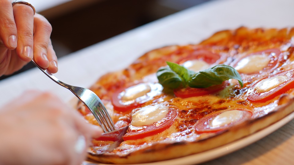 Comer pizza con cubiertos